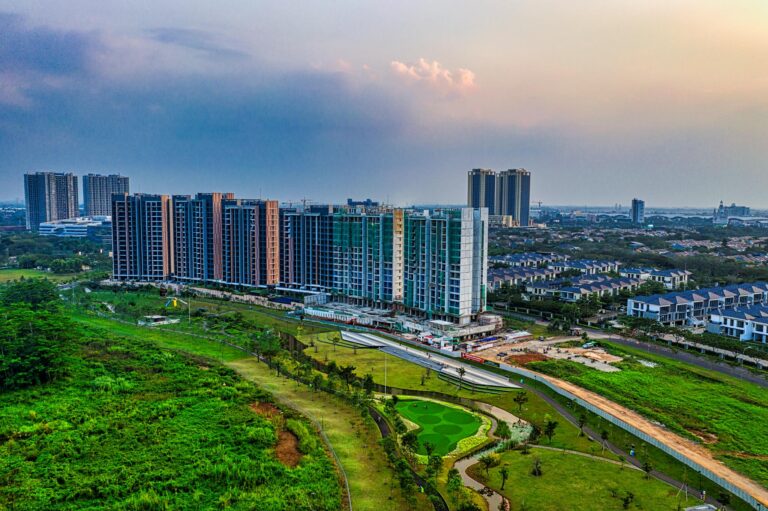 Drone shot capturing modern apartment buildings and green spaces in Banten, Indonesia at sunset.